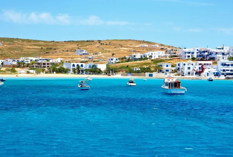 Cycladic coastline with charter yachts at anchor