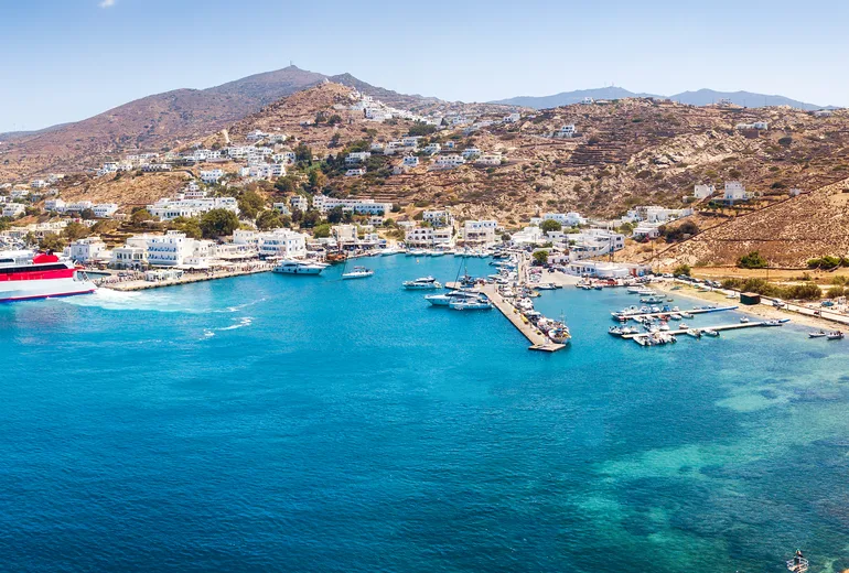 Aerial of Ios port with a ferry, yacht quay and hillside Chora