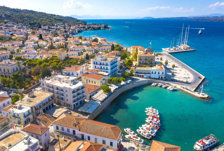 Aerial of Spetses old harbour with moored sailing yachts and red rooftops
