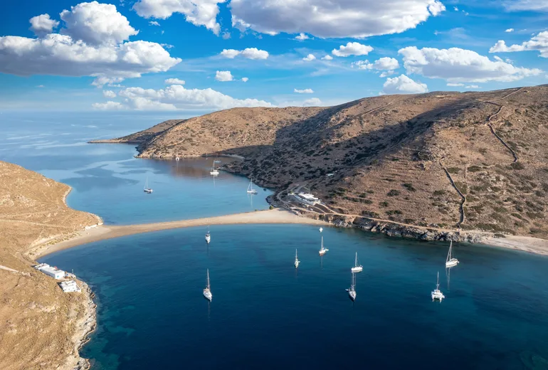 Aerial of the Kolona sandbar on Kythnos with sailboats anchored on both sides