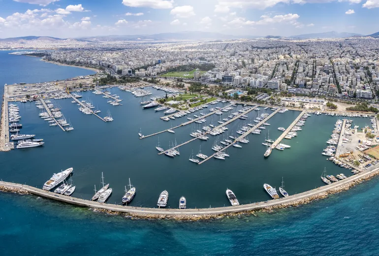 Aerial panorama of a vast city marina with rows of berthed yachts