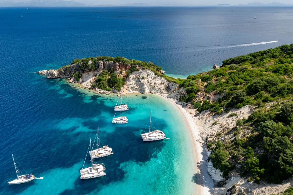 Catamarans anchored in a turquoise Ionian cove