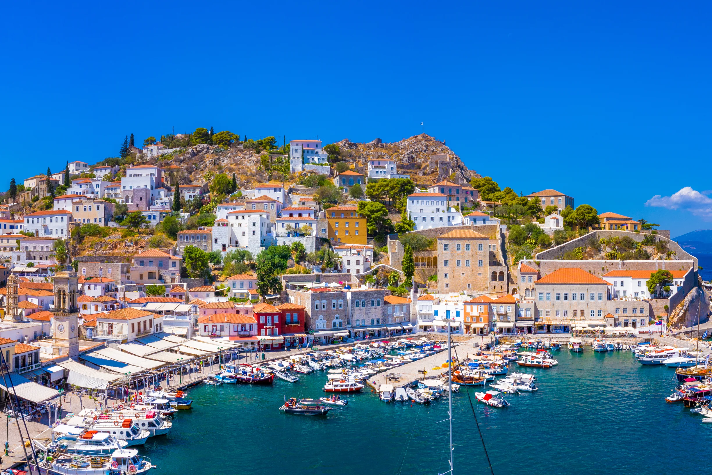 Panorama of Hydra town rising around its yacht-filled stone harbor