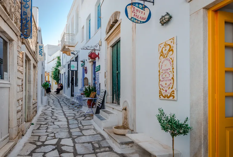 Marble-paved shopping lane in a Cycladic village with painted signs