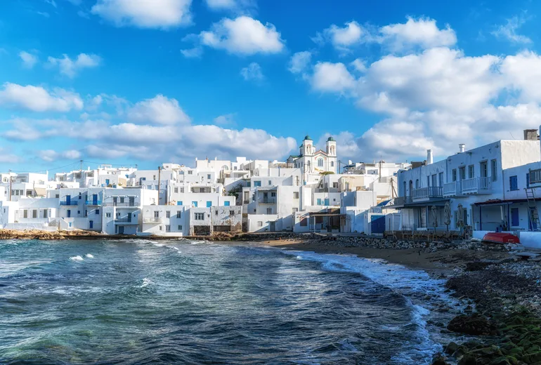 Whitewashed houses and church towers of Naoussa above the shore on Paros
